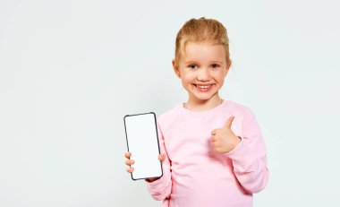 Beyaz arka planda izole edilmiş mesaj alanı için beyaz boş cep telefonu ekranı gösteren pembe elbiseli güzel bir kız. Reklam için boş alan.
