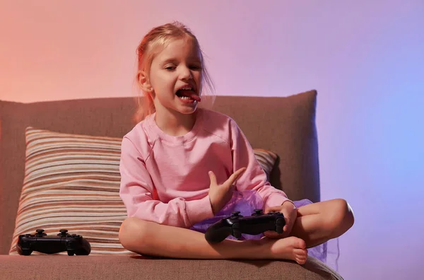 Nettes Kleines Mädchen Sitzt Auf Der Couch Und Hält Gamepad — Stockfoto