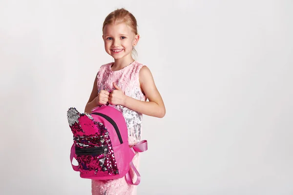 ピンクのスパンコールのドレスにウサギの耳のバックパックを持つかわいい女の子 子供時代 教育と人々の概念 灰色の背景を持つ幸せな子供の女の子 — ストック写真