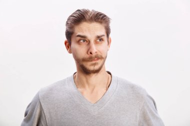 Düşünceli bir adamın portresi. Yakışıklı genç adam gri arkaplan fotokopi alanında izole edilmiş bir şey düşünüyor.