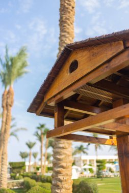 Bahçedeki büyük ahşap kuş besleyicisi, tropik bir tatil köyünde.