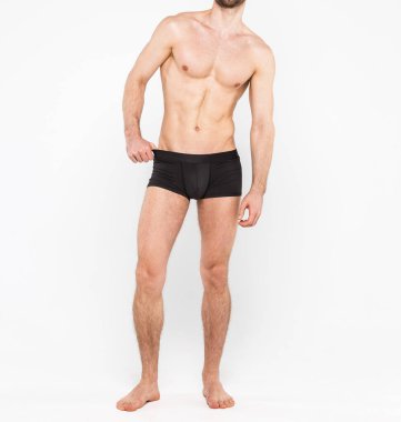 Beyaz arka planda izole edilmiş iç çamaşırı giyen kaslı genç bir adam. Erkekler için iç çamaşırı kopyalama alanı