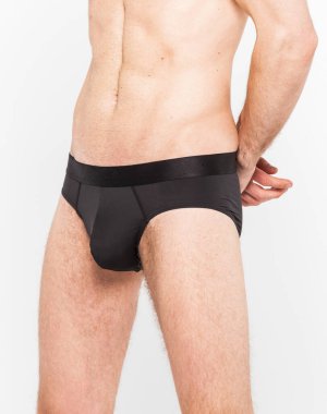 Beyaz arka planda izole edilmiş iç çamaşırı giyen kaslı genç bir adam. Erkekler için iç çamaşırı kopyalama alanı