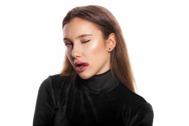 Güzel bir kadının yüz ifadesi portresi üst dudağı yalarken tek gözüyle göz kırparken beyaz arka planda izole edilmiş fotokopi çekilen kameraya bakıyor.