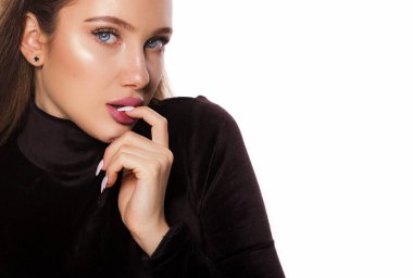 Mavi gözlü güzel bir kadının yüz ifadesi. Parmağını ısırıyor ve beyaz arka planda izole edilmiş fotokopi çekilen kameraya bakıyor.