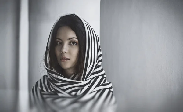 Portrait of a beautiful woman with scarf  on her head, near white wall — Stock Photo, Image