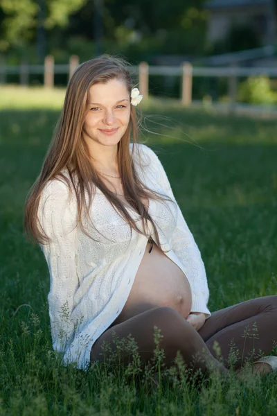 Happy mom Young pregnant woman relaxing at a park sitting on the — Stock Photo, Image