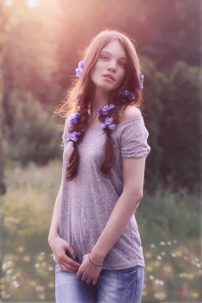 Young beautiful woman outdoors in garden  at sunset,  flowers in — Stock Photo, Image