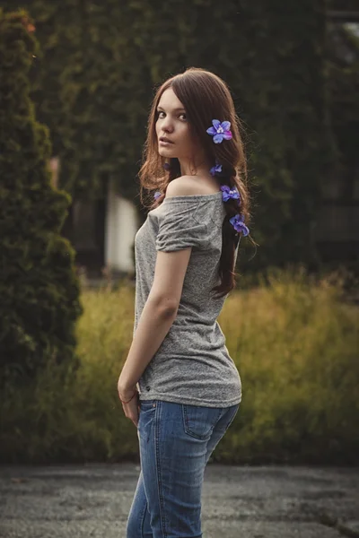 Young beautiful woman outdoors in garden  at sunset,  flowers in — Stock Photo, Image