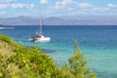 Yelkenli tekne, güneşli bir günde mavi suyu olan güzel bir körfezde yat, Chalkidiki, Yunanistan