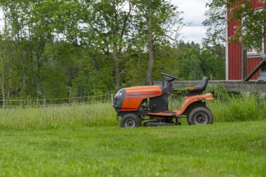 Evin yakınındaki bir bahçede çim biçme makinesine binmek, çim biçmek, bahçe tasarımı, bahçe işleri..