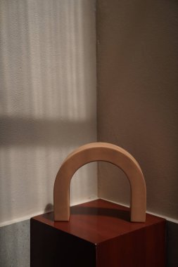 Kırmızı kürsüde, doğal ışık sahnesi konseptinde duvar arkaplanı olan Clay Ark vazosu. nesne / kopyalama alanı