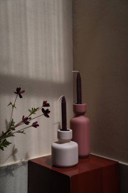 Kırmızı podyum ekranında kırmızı kadife mumlu kil vazo ve doğal ışık sahnesi konseptinde duvar arkası. nesne / kopyalama alanı