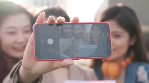 女性の友人のグループは 携帯電話と一緒に自撮りを取ります 友情の概念 キャンパス内の学生 — ストック動画