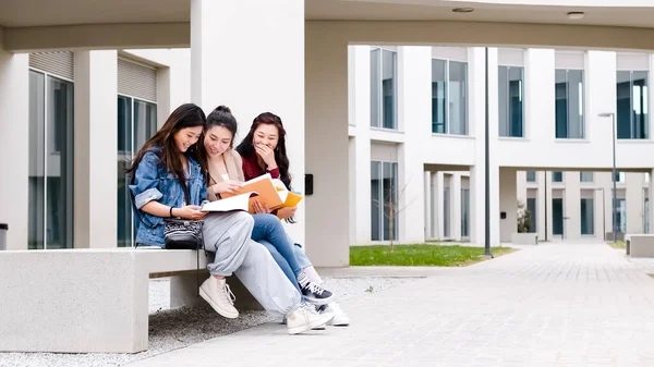 Drei asiatische Studentinnen reden in der Pause auf dem Campus — Stockfoto