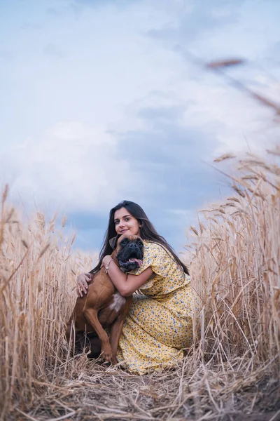 Portret młodej kobiety przytulającej psa na środku pola pszenicy. Pojęcie natury i zwierząt — Zdjęcie stockowe