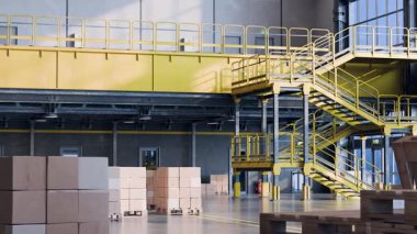 Geniş, temiz ve boş modern depo veya dağıtım merkezi içi paletlerin üzerinde karton kutular ve sarı bir merdiven