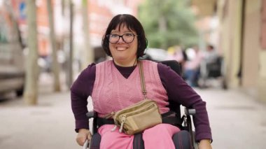 Engelli ve beyin felci geçirmiş olumlu bir kadın, şehir sokaklarında tekerlekli sandalyesinde otururken gülümsüyor. Kapsayıcı ve erişilebilir günlük yaşam