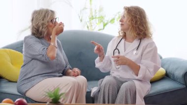 Yaşlı kadın doktorların yardımıyla ilaç alıyor, sağlık hizmetlerini ve refahı destekliyor.