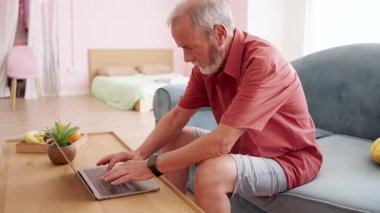 Yetişkin bir profesyonel, ev ofis ortamında uzaktan çalışma sırasında dizüstü bilgisayarda yazarken keskin bilek rahatsızlığı yaşıyor.