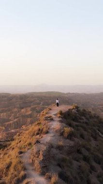 Uçurumun kenarında duran yalnız bir kadın, İspanya 'daki gorafe çölünün nefes kesici manzarasına bakıyor. Sihirli bir altın saat boyunca.