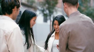 Dört farklı genç arkadaş sokakta keyifli bir sohbetin tadını çıkarıyor. Mutlu insanlar birlikte gülüyor, bir anlık dostluk paylaşıyorlar.