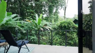 Özel bir balkondan, orman manzaralı cam duvarlarla çevrili büyük bir yatağı olan lüks bir otel odasına geri dönüyorlar.