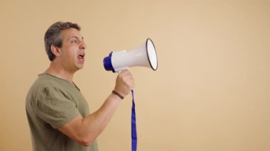 Öfkeli orta yaşlı bir adam bir duyuru yapmak için megafona bağırıyor. Eylemci, siyasi bir gösteri sırasında slogan atıyor