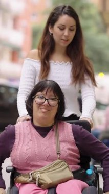 Serebral felçli, sakat bir kadın bakıcısıyla şehirde yürüyüş yapıyor. Engelliler için destek desteği
