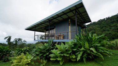 Sustainable tourism bungalow offering a balcony view of lush rainforest and natural habitat, promoting environmental responsibility