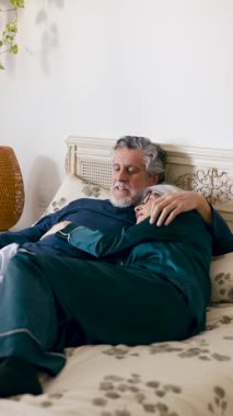 Beyaz pijamalı yaşlı bir çift parlak bir yatak odasında dinleniyor. Karı koca barışçıl, samimi ve sevgi dolu bir anı paylaşıyorlar. Dikey