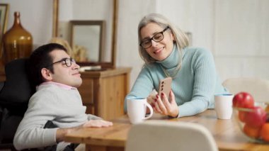 Fiziksel bir rahatsızlığı olan annesini ve oğlunu sevmek, birlikte vakit geçirmek, akıllı telefon kullanmak, konuşmak ve evdeki tahta masaya gülümsemek.