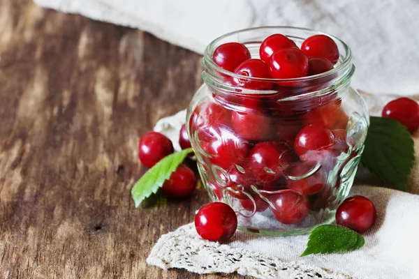 Cerezas frescas maduras en un frasco de vidrio —  Fotos de Stock