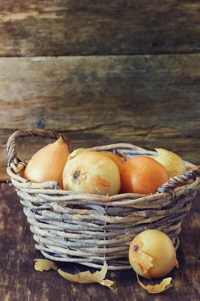 Ripe onion in a vintage basket — Stock Photo, Image