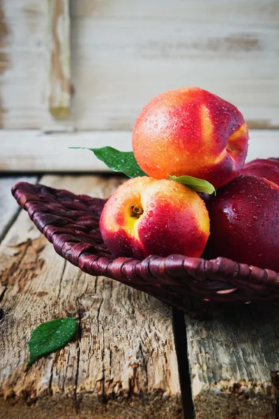 Nectarine in a wicker plate. — Stock Photo, Image