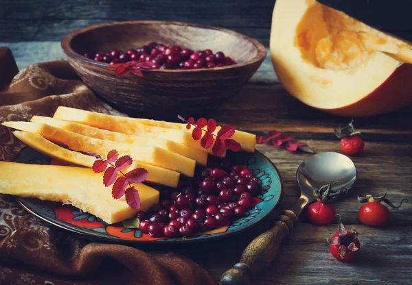 Reife Preiselbeeren und in Scheiben geschnittener Kürbis lizenzfreie Stockfotos