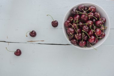 Beyaz bir kase içinde dağınık kiraz,