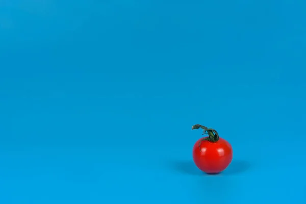 Kleine Rote Tomate Auf Blauem Hintergrund — Stockfoto