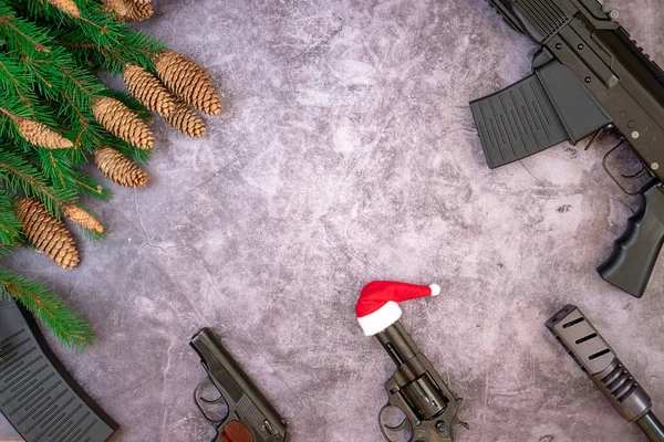 Broń, słuchawki, karabin maszynowy na szarym, betonowym tle. Koncepcja świąteczna — Zdjęcie stockowe