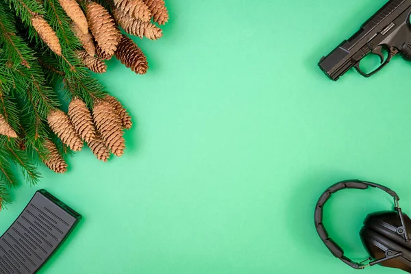 Fegyver, fülhallgató zöld háttérrel. Karácsonyi koncepció — Stock Fotó
