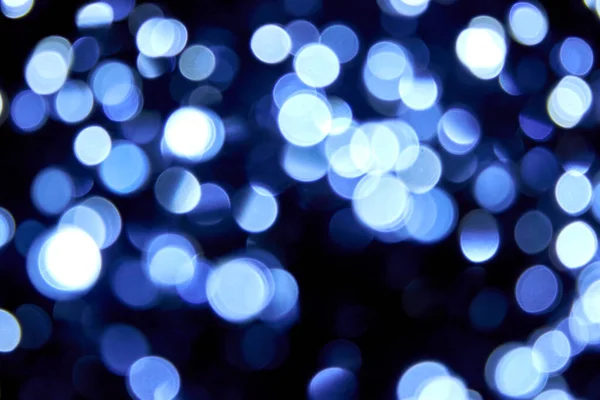 Odaklanamayan Bokeh Noel 'i siyah arka planda büyük mavi ışıklar. Bulanık soyut parıltı dokusu. Noel, yeni yıl ya da festival arka planı için mavi bokeh simli duvar kağıdı. 