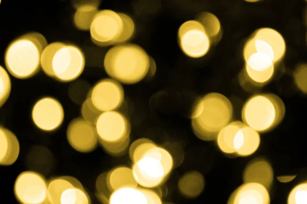 Siyah arka planda büyük altın ışıklar var. Bulanık altın parıltısı dokusu. Noel, yeni yıl ya da festival arka planı için altın parlayan duvar kağıdı.
