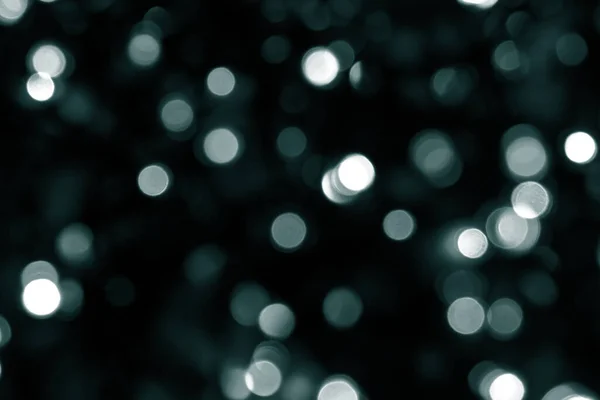 Bulanık yeşil parıltı dokusu. Tidewater yeşili renkler. Koyu yeşil arka planda bir sürü bokeh noel ışığı var. Noel, Yeni Yıl veya festival arka planı için yeşil bokeh simli duvar kağıdı. 