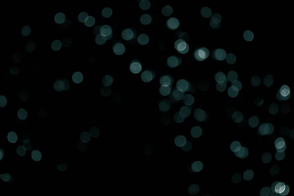 Odaklanamayan Bokeh Noel 'i siyah arka planda küçük yeşil ışıklar. Bulanık yeşil parıltı dokusu. Noel, yeni yıl, festival ya da tatil geçmişi için yeşil bokeh simli duvar kağıdı. Tidewater Yeşil Renkler.