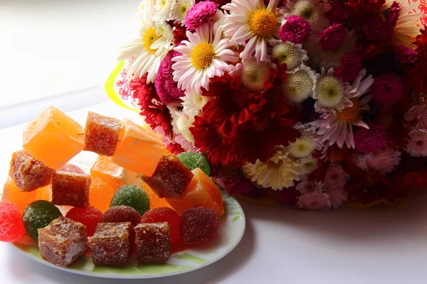 Autumn flowers and sweets — Stock Photo, Image