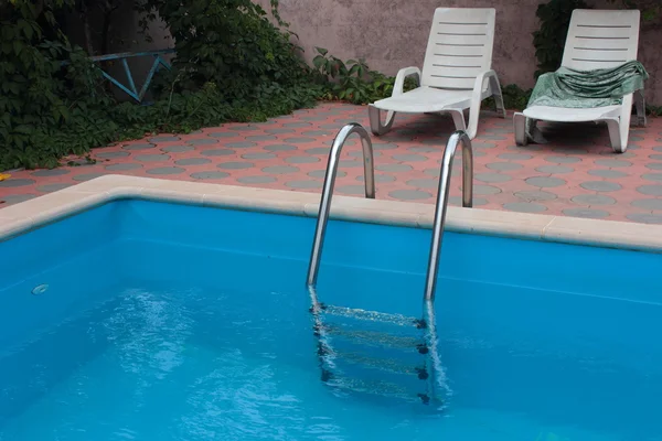 blue swimming pool with a ladder