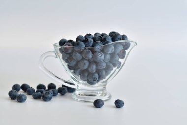 Nane yapraklı taze yaban mersini. Beyaz arka planda taze toplanmış yaban mersini. Sağlıklı organik mevsimlik meyve arka planı. Böğürtlenler yakında. Seçmeli odak