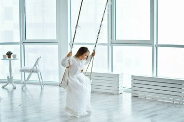 Pembe oyuncak flamingolu beyaz retro elbisesi olan tatlı, uzun saçlı kız salıncakta sallanıyor. arka plan Noel dekoru. Mutlu yıllar. Boşluğu kopyala