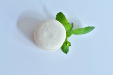 Beyaz arka planda nane izinleri olan beyaz vanilyalı kurabiyeler. Kapatın. Seçici odaklanma. Üst görünüm