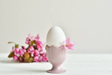 Tatlı tavşanlı ve beyaz masa arkasında taze çiçekler olan Paskalya bayramın kutlu olsun. Tebrik kartı. Paskalya geçmişi. Kopyala lütfen. Seçici odak